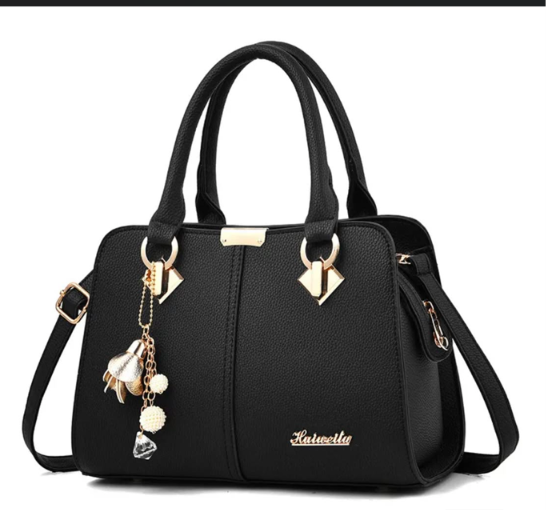 Black handbag with twin handles, shoulder strap, and gold-tone details